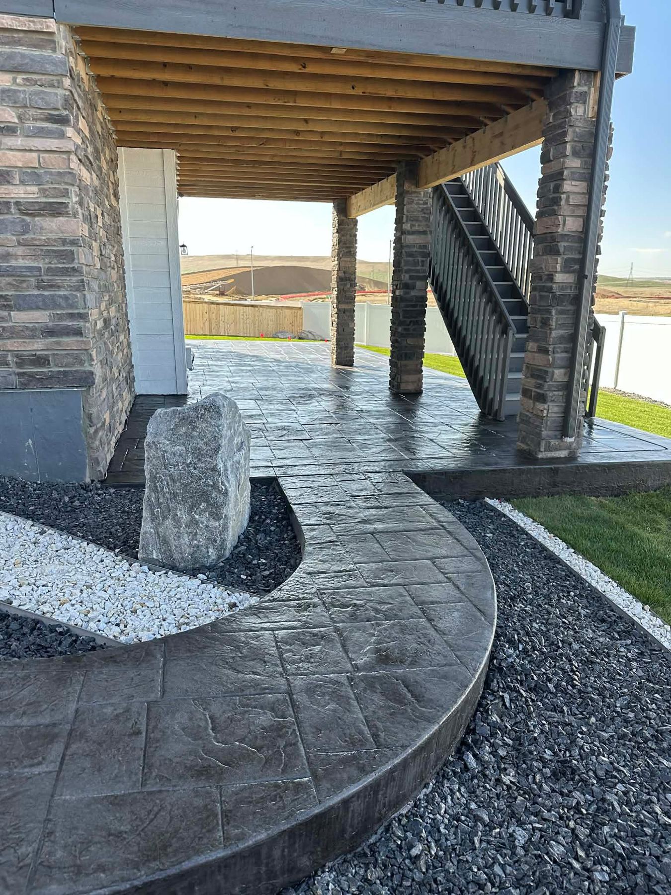 Concrete patio under deck with stone pillars, Denver Metro, CO